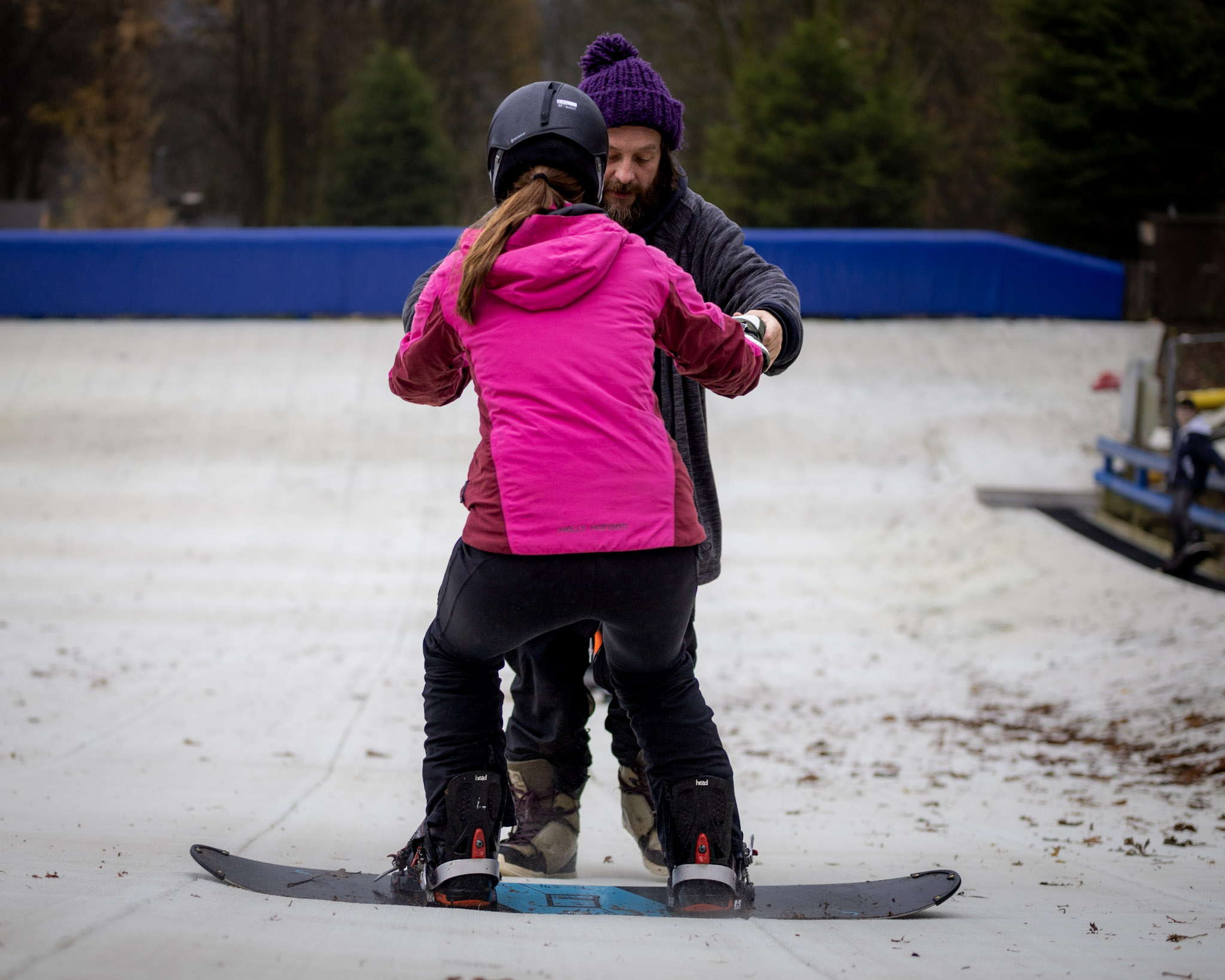 Snowboard instructor on our intermediate slope teaching a female student